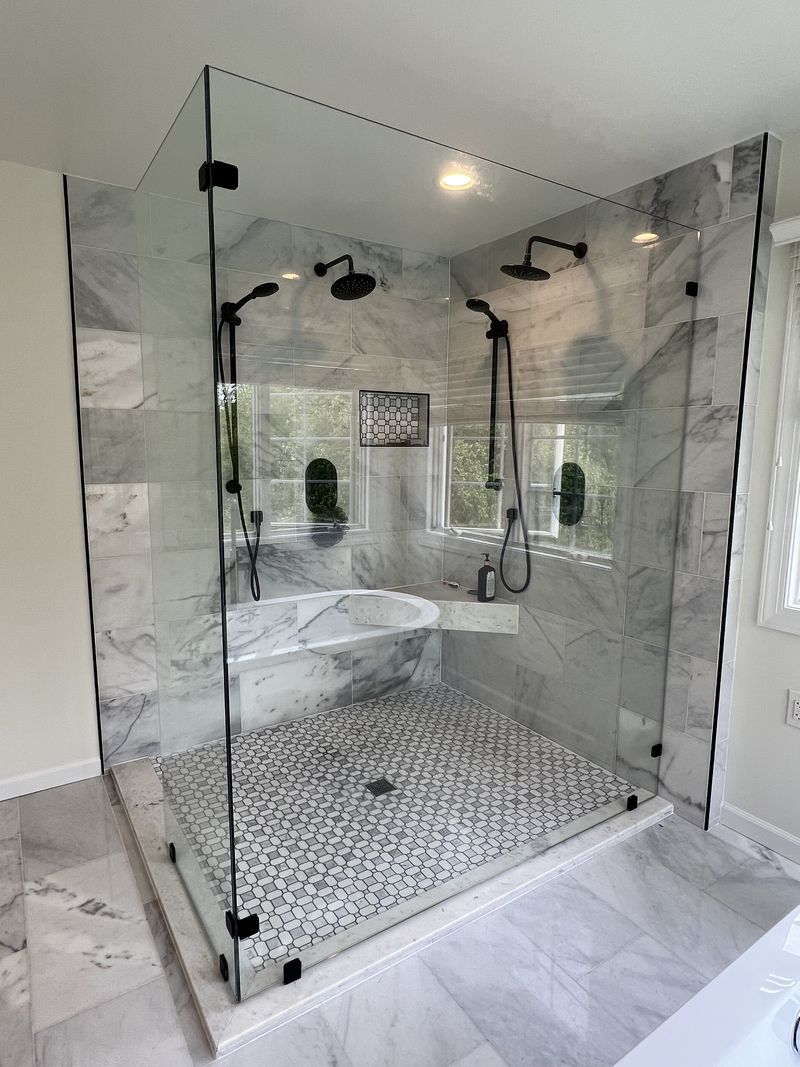Large frameless glass double shower with marble tile and built-in bench, bathroom renovation in Chester County PA